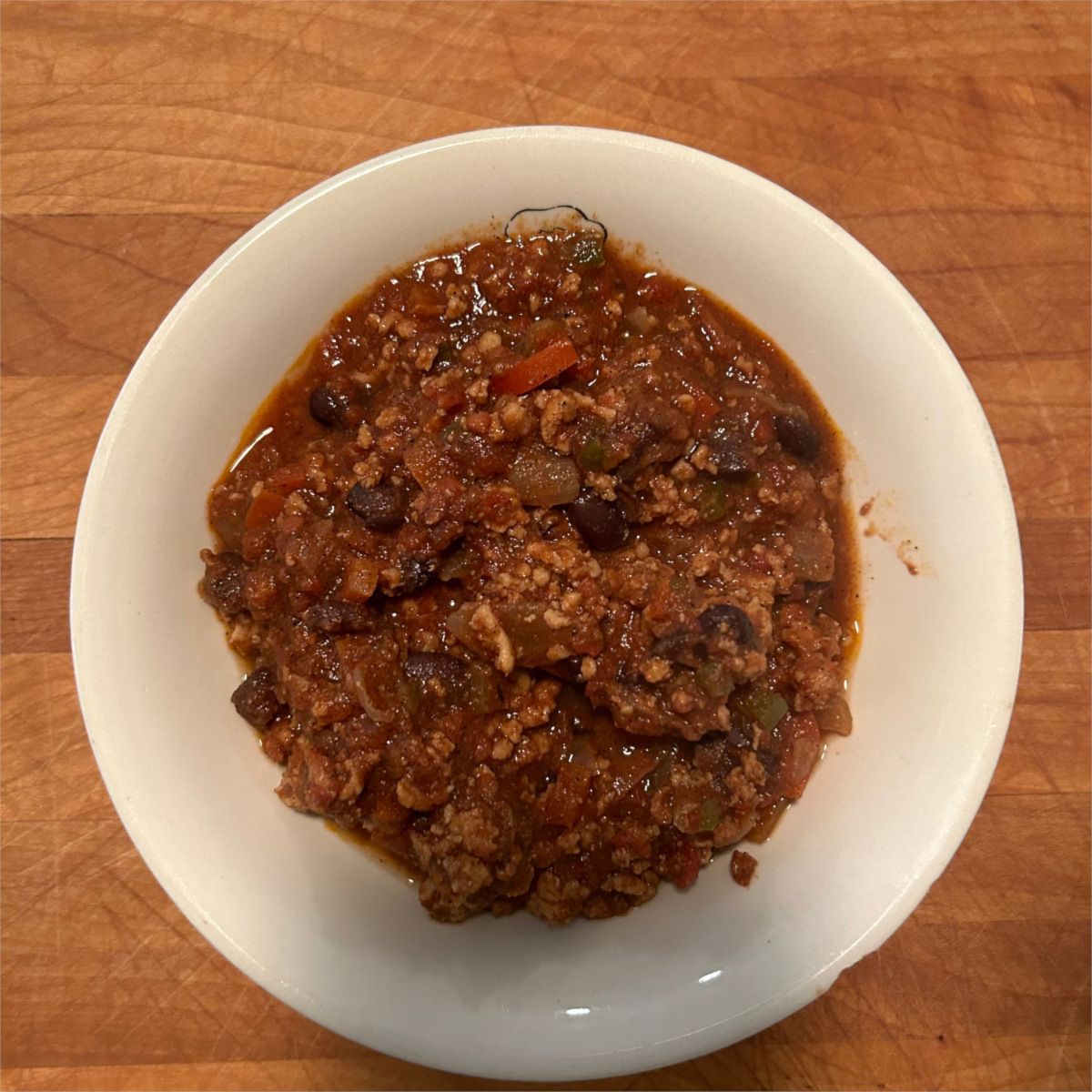 Finished Chicken Chili in white bowl on cutting board